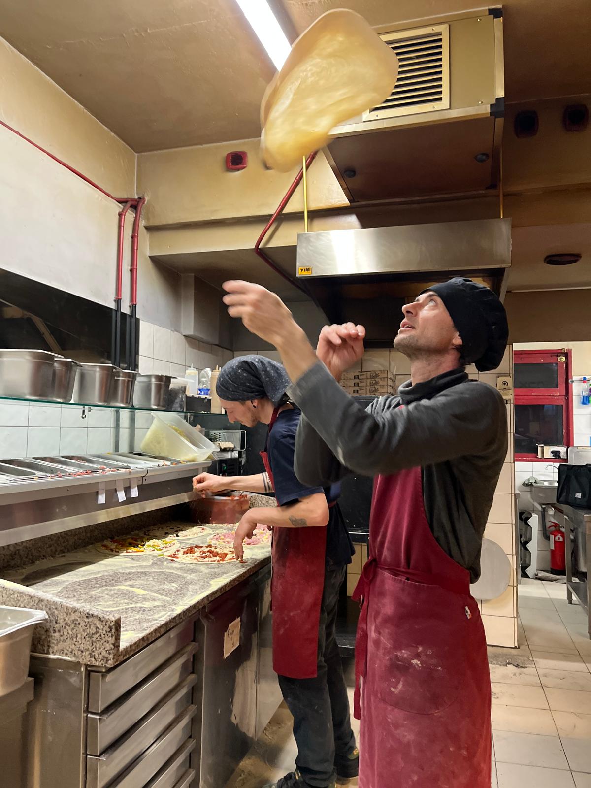 Un pizzaiolo lance la pâte en l'air